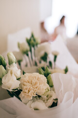 Close-up of white flower bouquet with soft background, wrapped in paper, romantic floral decor
