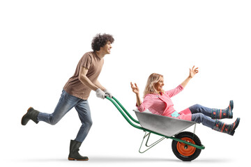 Young man pushing a mature woman in a wheelbarrow