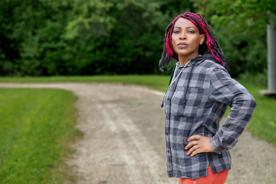Athletic African American Woman with Colorful Braids Walking on Park Path for Exercise - Powered by Adobe