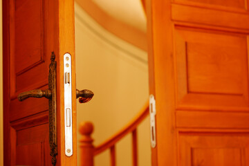 Open wooden door revealing curved staircase interior