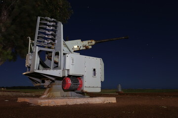 Stationary old, historic air defense artillery gun against night sky. Used to intercept and destroy aircraft, missiles, other airborne threats. Remembrance, Anzac Day. Lest we forget