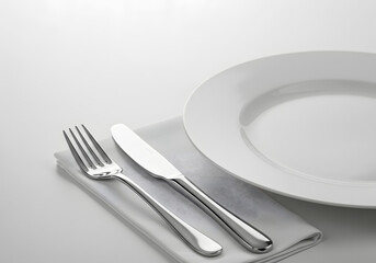 Plate setting, empty white plate with fork and knife on a dinner table setting