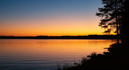 Orange Sunset Over Calm Lake with Tree Silhouettes