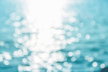 Bokeh white glitter on bright blue sea water background