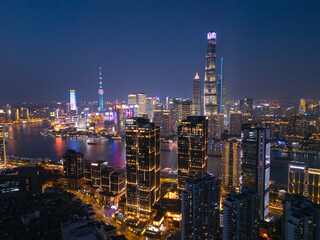Aerial view of Shanghai skyscrapers in downtown and winding river at night.