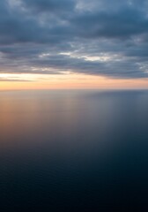 Obraz premium Serene Ocean Sunset: Tranquil Water, Gradient Sky