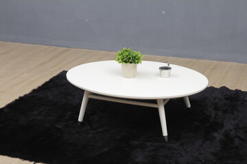 Minimal white round coffee table with small plant decor in a modern interior setting. Ideal for furniture advertising, home decor concepts, minimalist lifestyle, and interior design use.