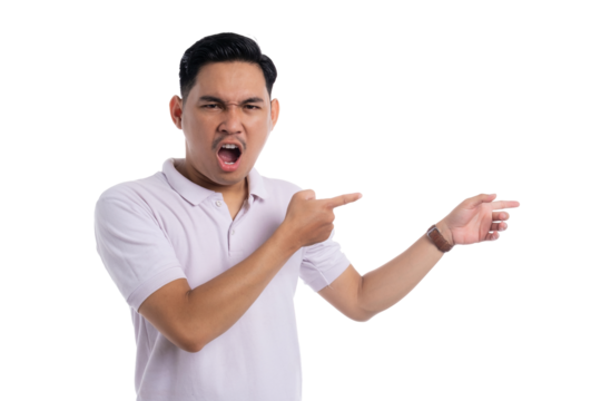Angry young man shouting and pointing to the side with furious expression isolated on transparent background