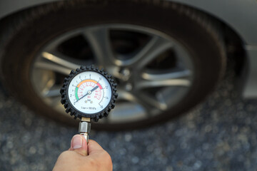 Mechanic holding car tire pressure to checking low tire pressures inflating tires to or refill or...