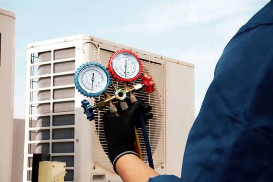 Air conditioning electrical technician service using measuring manifold gauge checking HVAC condition system and refrigerant filling air conditioner after cleaning and maintenance compressor units.