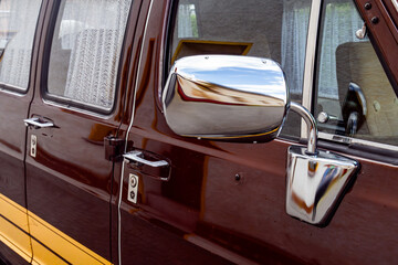 Side view mirror and doors of vintage brown van with chrome details © Mario