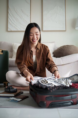 Female traveler organizing essentials in her luggage before leaving for a vacation.