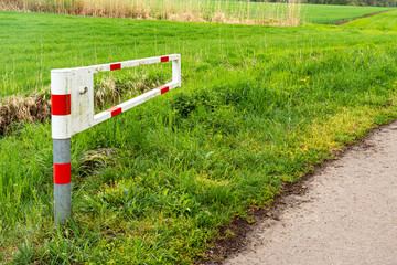White and red barrier pole on rural roadside