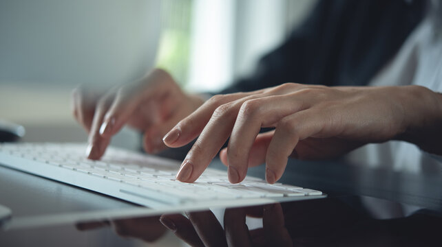 Closeup, business woman working on desktop computer. Corporate business woman hand typing on keyboard, searching the information, surfing the internet on office table, remote work, business background