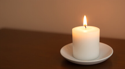 Burning White Candle on a Saucer with Warm Background Lighting