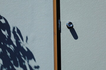 長野県諏訪市霧ヶ峰のプレハブ小屋のドアと葉っぱの影