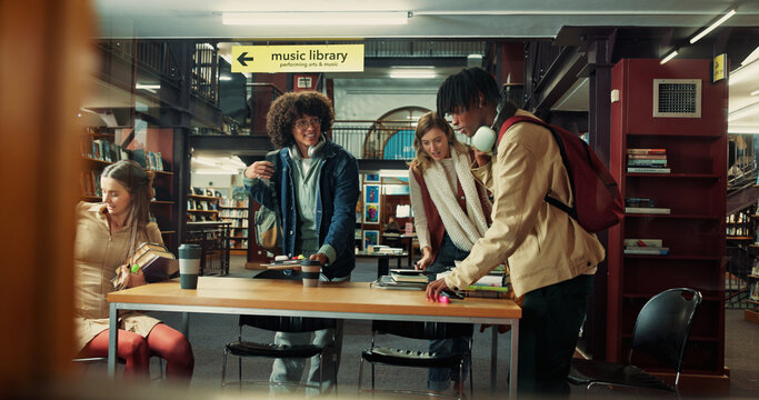 Education, books and group of students studying in library for university test, project or exam. Arriving, happy and friends preparing for college assignment together with scholarship at campus.