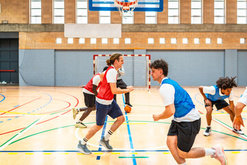 Basketball players running on court during training