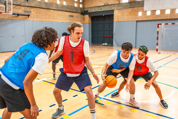 Basketball players defending and attacking during training in a gymnasium