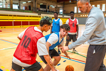 Basketball coach explaining game strategy to young players during training