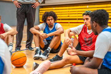 Basketball players listening to coach during time out