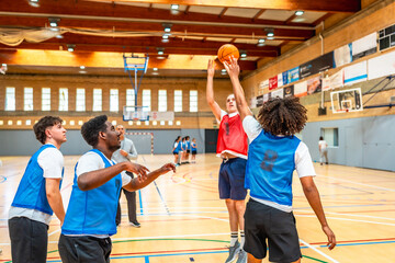 Basketball player shooting ball during training in gym