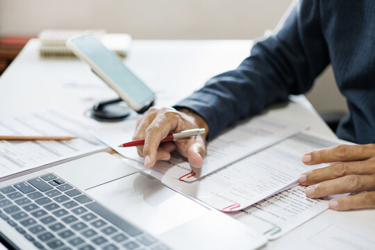 close-up shot, hand of businessman reviewing document at office. legal expert, professional lawyer working with computer reading and checking financial documents and business contract - Powered by Adobe