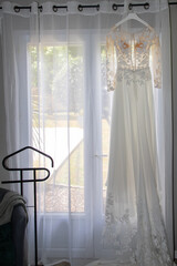 marriage white wedding dress of bride hangs in windows home in celebration day