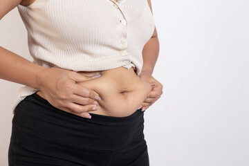 Overweight woman hand pinching excessive belly fat on gray background, Healthy concept