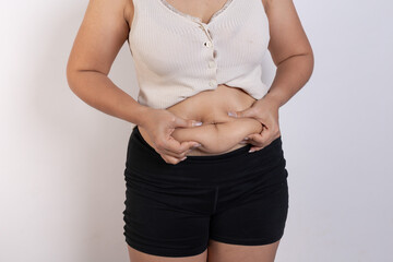 Overweight woman hand pinching excessive belly fat on gray background, Healthy concept