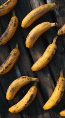 Ripe bananas with dark spots on a rustic wooden background, full frame