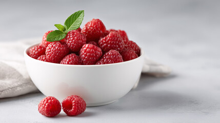 Raspberry Abundance: A bowl filled with fresh, vibrant red raspberries, complemented by a sprig of mint, offers a visual feast, capturing the essence of freshness and the allure of nature's bounty. 