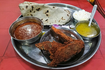 Tilapia fish fry in a plate. prepared hot and spicy.Tilapia masala spicy curry meat food in a plate with rice and naan bread