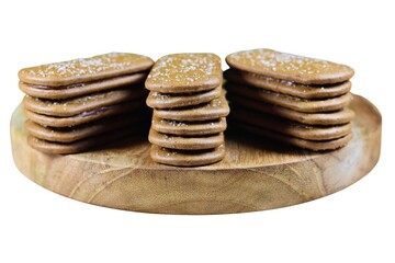 Close up of chocolate biscuits on a round wooden chopping board.