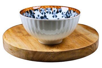 Empty ceramic bowl on round wooden cutting board.