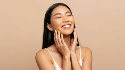 A young asian woman smiles happily while touching her face