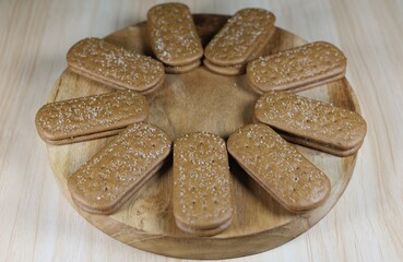 Close up of chocolate biscuits on a round wooden chopping board.