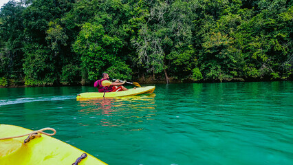 Young man kayaking on the river in a sunny day. Sport and active life concept.