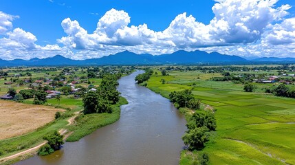Obraz premium Aerial View of a Serpentine River in Lush Green Valley Under a Blue Sky with Fluffy Clouds