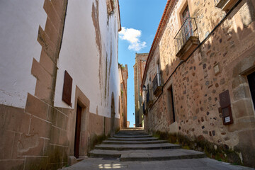 Old Town of Caceres, cobblestone street and centuries-old buildings with a blue sky in the background