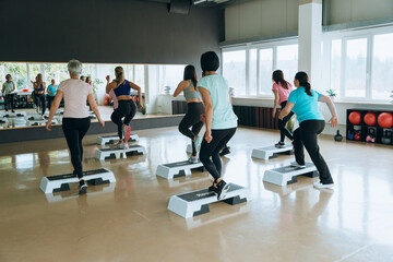 Group fitness class using steppers in gym for cardio exercise active lifestyle and wellness