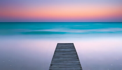 Naklejka premium A wooden pier extending into the calm ocean water under a pastel colored sky at sunset or sunrise