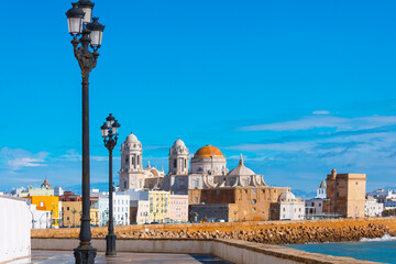 Stunning view of Cadiz, featuring iconic Cadiz Cathedral with golden dome and twin towers against...