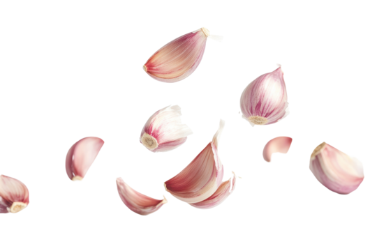 Floating garlic cloves create a dynamic and visually striking display against a stark white background, showcasing their unique shapes and colors during culinary preparation