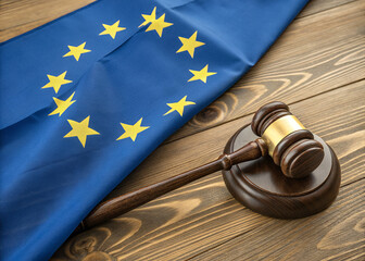 EU Law and Justice: A gavel rests upon a wooden base, with EU flag as backdrop, symbolizing the scales of justice, law, and order within the European Union.