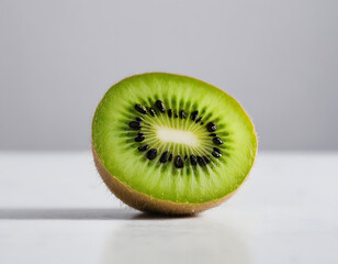 A sliced kiwi fruit showing green flesh and tiny black seeds, close-up photo, minimal white setup