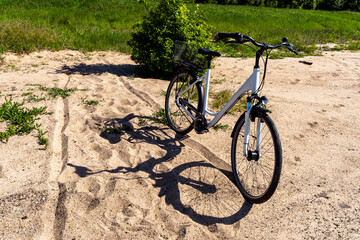 Bike parked on sandy path near grassy field