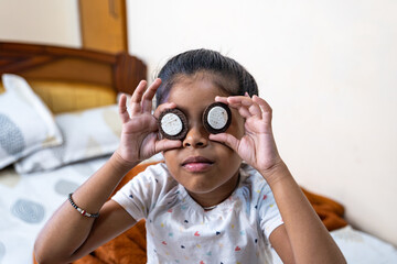 Child playing with cookies on a bed at home