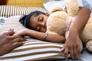 Child sleeping peacefully with teddy bear in cozy bedroom
