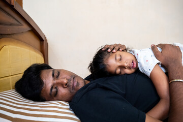 Father and daughter resting together on a bed